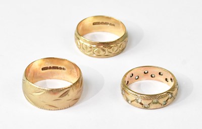 Lot 1128 - Three 9ct gold band rings, one with floral...