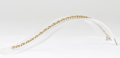 Lot 1148 - A 9ct gold diamond and emerald set line...