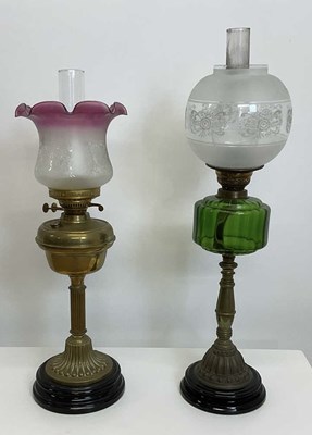 Lot 428 - Two oil lamps with brass bodies mounted on...