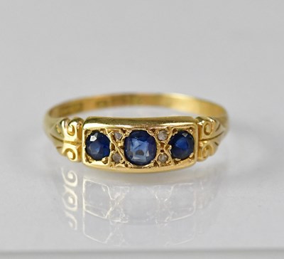 Lot 1077 - An Edwardian 18ct gold three-stone sapphire...