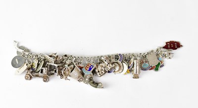 Lot 1160 - A silver charm bracelet with forty-two charms...