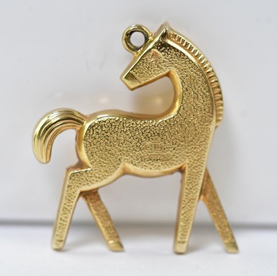 Lot 1179 - A 9ct gold contemporary horse pendant, length...