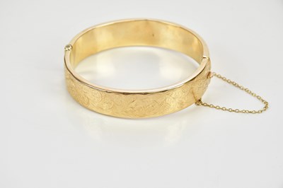 Lot 414 - A 9ct gold hinged snap bangle, internal width...