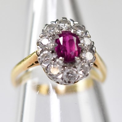 Lot 1074 - An 18ct gold ring with claw set ruby within a...