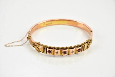 Lot 444 - A 9ct yellow gold oval hinged bangle set with...