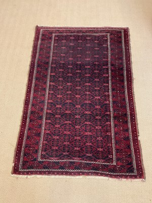 Lot 447 - A Persian Bukhara rug with a deep red...