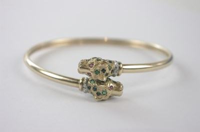 Lot 434 - A yellow metal bangle with twin leopard head...