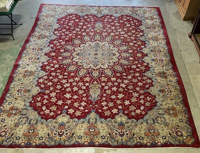 Lot 439 - A large Persian red ground carpet with...