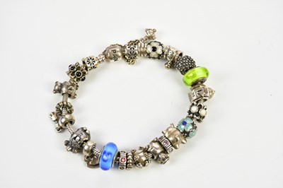Lot 495 - PANDORA; a silver charm bracelet set with...