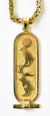Lot 1121 - An Eastern yellow metal pendant, embossed with...