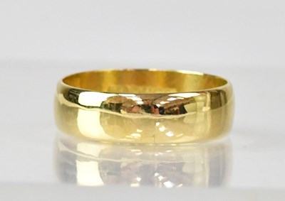 Lot 1063 - An 18ct gold wide wedding band, size, P1/2,...