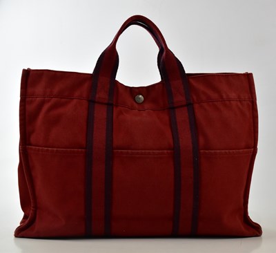 Lot 753 - HERMÈS; a dark red canvas 'Herline' tote bag...