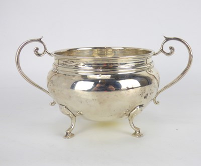 Lot 660 - A George V hallmarked silver twin-handled bowl raised on scroll and pad feet