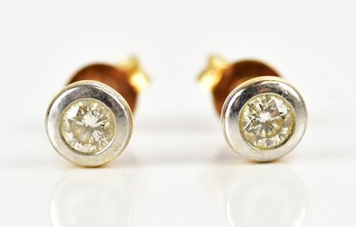 Lot 1680 - A pair of yellow metal collet set diamond ear...