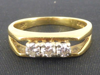 Lot 750 - An 18ct gold three-stone claw set diamond ring,...