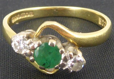 Lot 747 - An 18ct gold diamond and emerald ring, the...