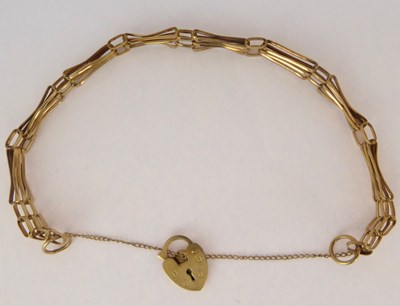 Lot 794 - A 9ct gold three bar gate bracelet with...