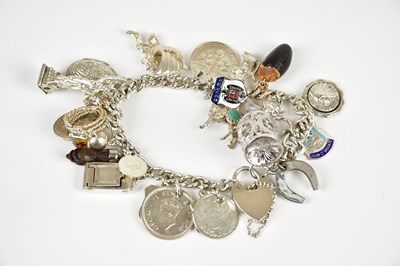 Lot 1754 - A white metal charm bracelet suspending...