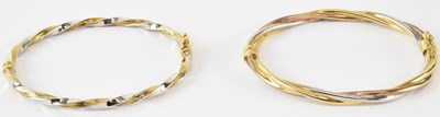 Lot 729 - A pair of 9ct white and yellow gold bangles,...