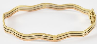 Lot 745 - A 9ct yellow gold three strand bangle,...