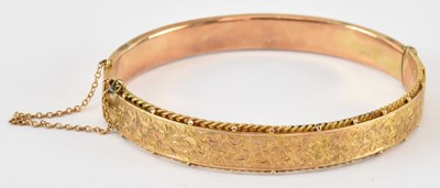 Lot 759 - A 9ct gold hinged hollow bracelet, with floral...