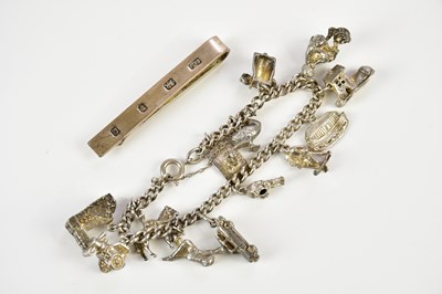 Lot 423 - A silver charm bracelet and a silver tie slide,...