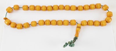 Lot 877 - A butterscotch amber effect bead necklace,...