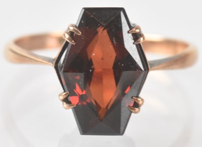 Lot 873 - A 9ct yellow gold red stone set ring, size M,...