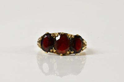 Lot 198 - A 9ct yellow gold garnet three stone ring,...