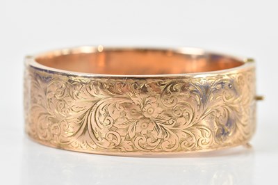 Lot 1553 - A 9ct rose gold oval hinged snap bangle, with...